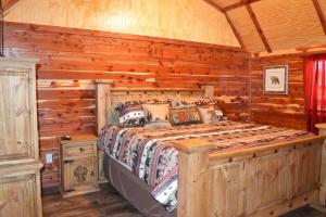 a bedroom with a bed in a log cabin at Secluded Getaway on a Vineyard in Allen, Oklahoma in Allen
