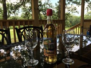 a bottle of wine sitting on a table with two glasses at Secluded Getaway on a Vineyard in Allen, Oklahoma in Allen