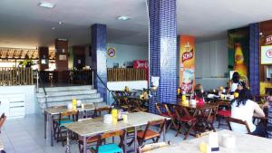 a restaurant with tables and chairs and people eating in it at Studio Lateral Vista Mar Barra Apartamento Inteiro Completo in Salvador