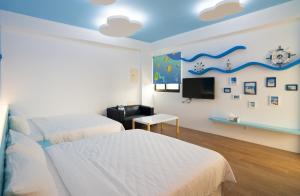 a bedroom with two beds and a flat screen tv at Sunny Breeze Penghu in Magong