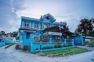 a blue house on the side of a street at Hotel O Adela in Laguboti