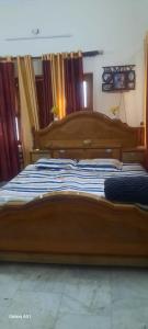 a large wooden bed sitting in a bedroom at Devaa Homstay in Mau