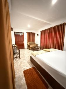 a bedroom with a bed and a chair in a room at Bael House Ahangama in Ahangama