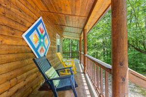 a porch of a cabin with two chairs on it at WiFi & Pet Friendly - The Road's End in Rogers