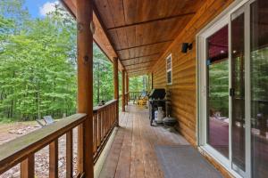 a porch of a wooden house with a large window at WiFi & Pet Friendly - The Road's End in Rogers