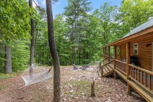 a log cabin with hammocks in the woods at WiFi & Pet Friendly - The Road's End in Rogers