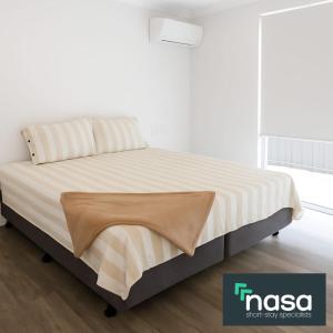 a bed with a blanket on it in a room at Milbridge Getaway with a bathroom in each room in Eaton