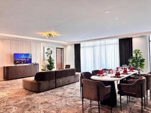 ダナンにあるNesta Celia Da Nang Hotelのテーブル、椅子、ソファが備わるホテルルームです。