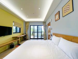 金湖鎮にある王老爺花園民宿の大きな白いベッドとテレビのある寝室