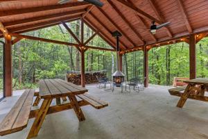 a wooden pavilion with a picnic table and a fireplace at The Overlook - Camping Cabin Retreat in RRG KY in Rogers