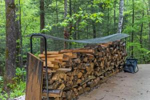 a pile of fire wood with a hammock on top at The Overlook - Camping Cabin Retreat in RRG KY in Rogers