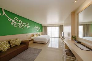 a hotel room with a bed and a couch and a desk at Aspira Petchkasem in Ban Khlong Om Noi