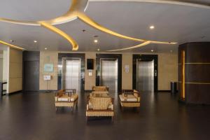 a lobby with chairs and a circular ceiling at Aspira Petchkasem in Ban Khlong Om Noi