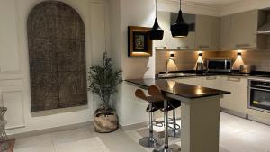 a kitchen with a counter and a island with stools at 1 Constitution Avenue By Goldfinch in Islamabad