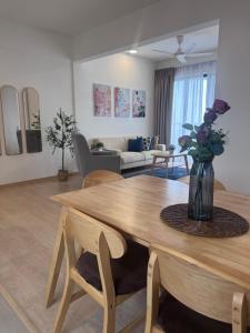 a living room with a table with a vase of flowers at SEAVIEW - BEACHFRONT - 2BR Apartment - Corner Unit- Mutiara Melaka Beach Resort Pantai Puteri in Melaka