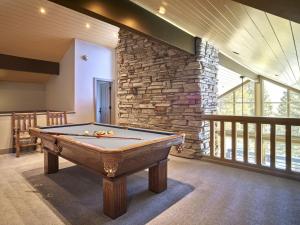 a pool table in a room with a stone wall at RMR: Sublette Ridge Ski Lodge in Teton Village in Teton Village