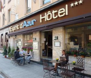 فندق Esprit d'Azur في نيس: مجموعة من الناس يجلسون على الطاولات خارج الفندق