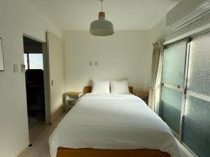 een slaapkamer met een groot wit bed en een raam bij Wi-fi4ac3tv55"30 in Osaka