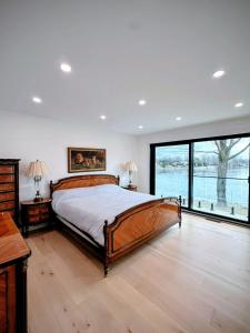 a bedroom with a large bed and a large window at Aqua Luxury House on the Shore in Laval