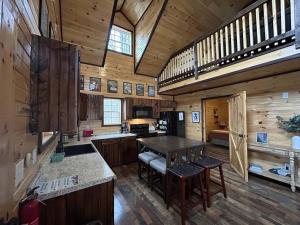 a large kitchen with a table in a cabin at WiFi & Hot Tub Large Family - Climb On in RRG in Rogers