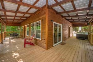 a wooden house with a large wooden deck at WiFi & Hot Tub Large Family - Climb On in RRG in Rogers