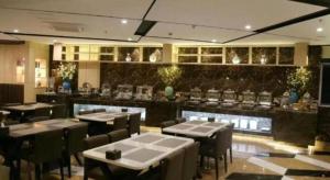 GaoyouにあるGreenTree Inn Gaoyou Governmentのレストラン内のテーブルと椅子のあるダイニングルーム