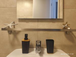 にあるCasa con parra de uva y pazのバスルーム(洗面台、2つのカップ、鏡付)