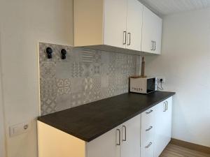 にあるCasa con parra de uva y pazの白いキャビネットと電子レンジを備えたキッチン +17枚の写真