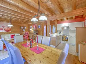 a dining room and kitchen with a wooden table and chairs at Holiday Village Wildschönau Chalet with Garden in Niederau