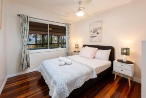 a bedroom with a bed and a window at Pet friendly beachfront home- sleeps 8 in Toogoom