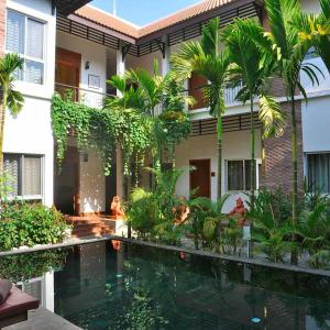 a hotel with a swimming pool in front of a building at La Fontaine de Tara in Siem Reap