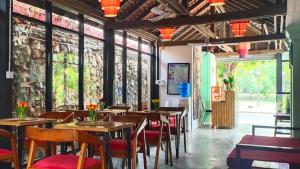 a restaurant with wooden tables and chairs and windows at La Fontaine de Tara in Siem Reap