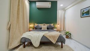 een slaapkamer met een bed en een groene muur bij Hotel Broholi Height Inn Near Hafeezpet Railway Station in Hyderabad