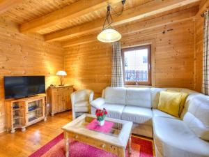 a living room with a white couch and a tv at Feriendorf Wildschönau -Cozy Escape in Niederau