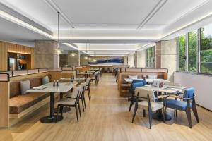 a restaurant with tables and chairs and windows at Fairfield by Marriott Shanghai Xuhui Center in Shanghai