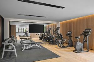 a gym with a bunch of exercise equipment and a flat screen tv at Fairfield by Marriott Shanghai Xuhui Center in Shanghai
