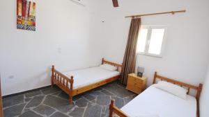 a room with two beds and a window at Ampelos apartment and studios in Xerokampos