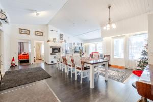 a dining room and living room with a table and chairs at Rovaniemi Riverside Family House near Santa Claus Village - Sauna & Aurora View in Rovaniemi +25 photos