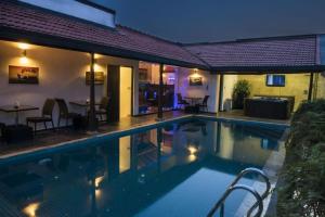 a swimming pool with a table and chairs next to a house at D Villas in Kirillapone