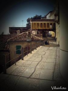 una calle vacía con un gran edificio en el fondo en B&B Monferrato La Casa Sui Tetti, en Murisengo