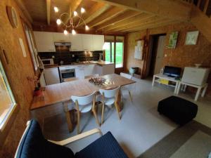 een keuken en eetkamer met een tafel en stoelen bij Gîte Chalet Morvan Bourgogne in Corancy