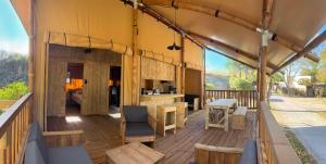 a large wooden deck with a kitchen on a house at Camping Le Val de Cesse in Mirepeisset