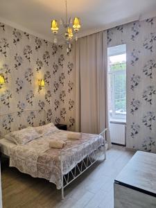 a bedroom with a bed with a floral wallpaper at Old Tbilisi Apart-Hotel in Tbilisi City