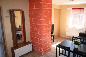 a room with a brick pillar with a table and a mirror at Privatzimmer San in Ringsheim
