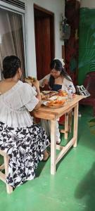 two women sitting at a table eating food at Talblick Valley in Ella