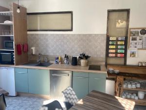 a kitchen with blue cabinets and a counter top at A deux pas du Rheby in Villebois