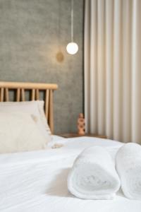 a bedroom with white towels on a bed at ארץ-נגב צימרים בירוחם in Yeroẖam