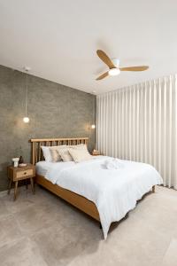 a bedroom with a large bed with a ceiling fan at ארץ-נגב צימרים בירוחם in Yeroẖam +17 photos