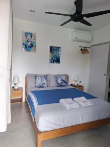 a bedroom with a bed with a ceiling fan at Bungalow Khao Lak in Khao Lak