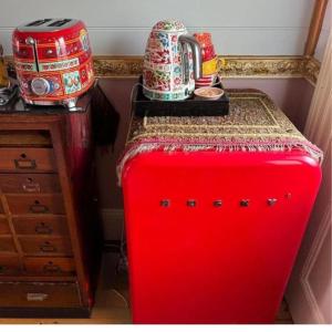 Una maleta roja con una mesa encima. en Chinoiserie, en Katoomba
